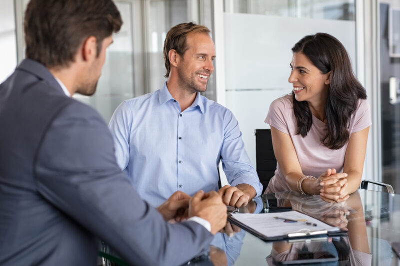 smiling couple meeting attorney